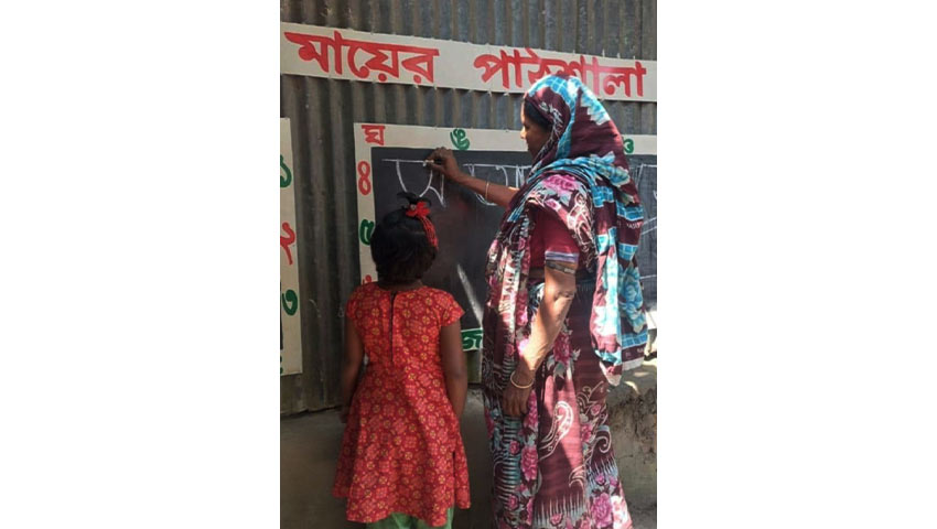 লিখতে শিখছেন একজন মা। ছবি : সৌজন্য